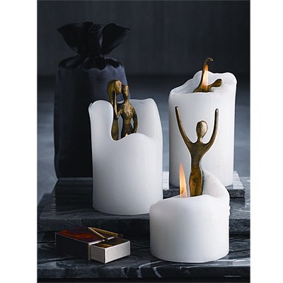 three white lighted candles and an open matchbox