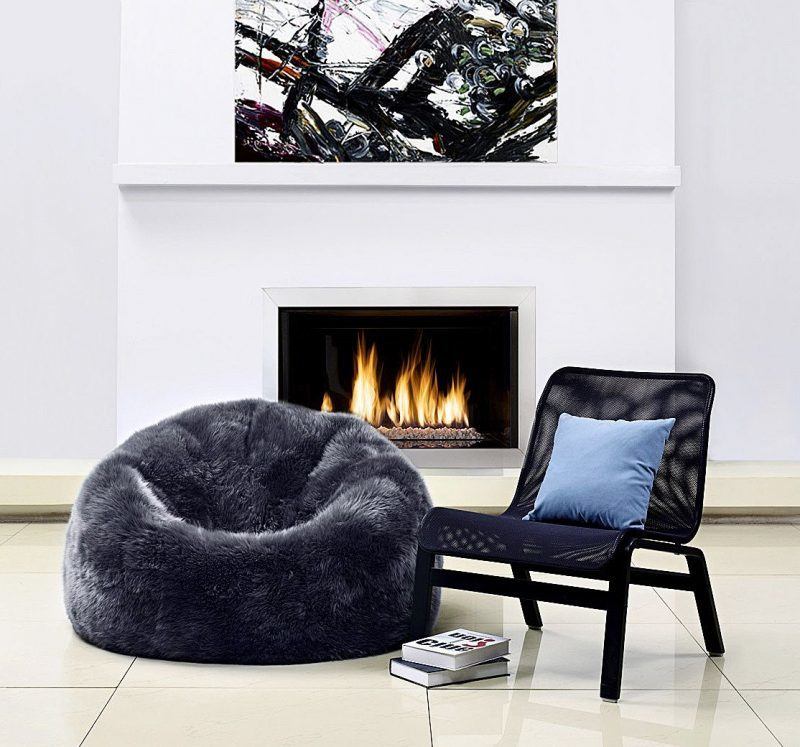 a black chair and black beanbag with books on floor