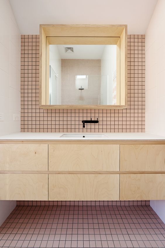 pink bathroom tile with natural wood vanity